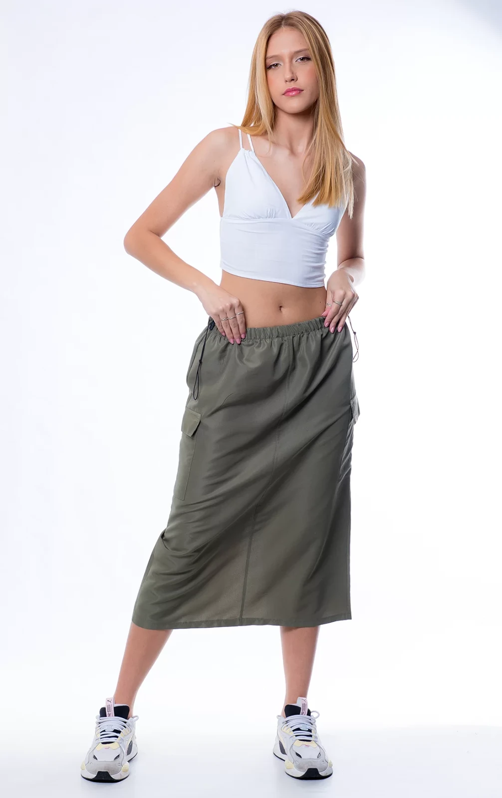 Menina Loira vestindo uma saia midi cargo na cor militar e um cropped de alçinha branco